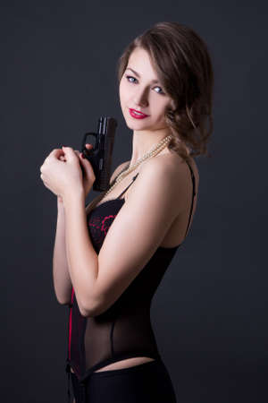 beautiful sexy woman in lingerie with gun over grey backgroundの写真素材
