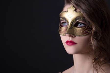 close up portrait of beautiful woman in mask over grey backgroundの写真素材