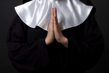 religion concept - hands of woman nun praying over grey backgroundの写真素材