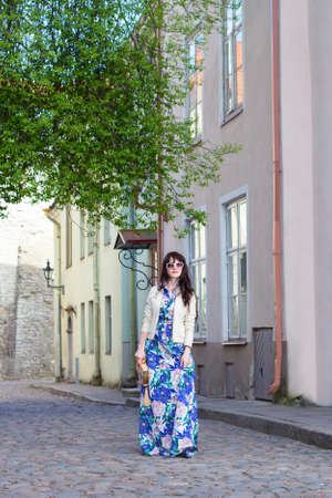 young woman in long dress walking in old town of Tallinn, Estoniaの写真素材