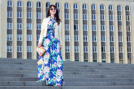 portrait of young beautiful business woman posing over big buildingの写真素材