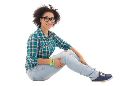 beautiful african american teenage girl sitting isolated on white backgroundの写真素材