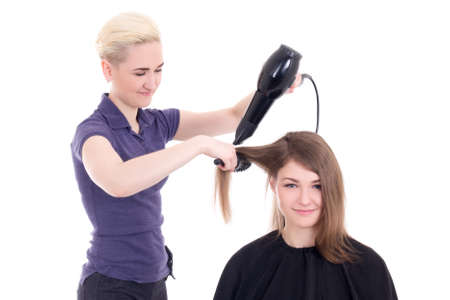 happy woman hair stylist doing haircut to client isolated on white backgroundの写真素材