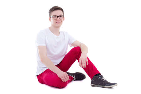 happy young handsome man in white t-shirt sitting isolated on white backgroundの写真素材