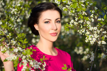 young beautiful woman in blooming spring gardenの写真素材