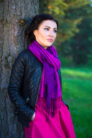 young beautiful woman standing near the tree in spring forestの写真素材