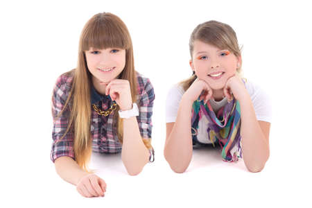 two happy teenage girls lying isolated on white backgroundの写真素材
