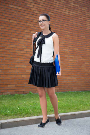 school concept - beautiful smiling teenage girl with backpack walking in campus