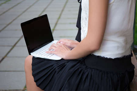 close up of girl in school uniform using laptop with blank screenの写真素材