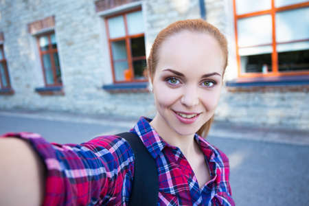 happy beautiful student or school girl making selfie photoの写真素材
