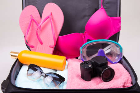 preparation for trip concept - packed suitcase full of vacation items