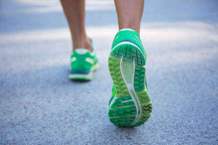 sport concept - close up of female legs running on roadの写真素材
