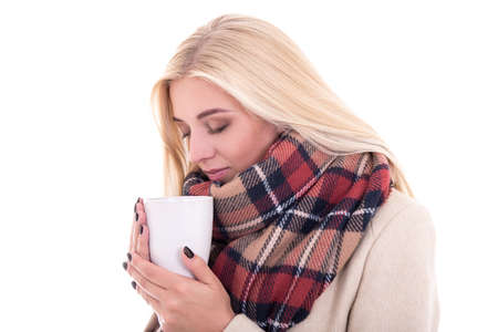 close up portrait of blond woman in warm clothes with cup of coffee or tea isolated on white backgroundの写真素材