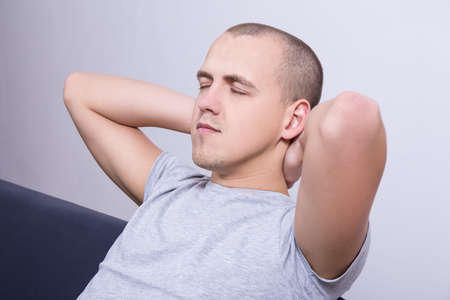 relaxation concept - young man lying on sofa at homeの写真素材