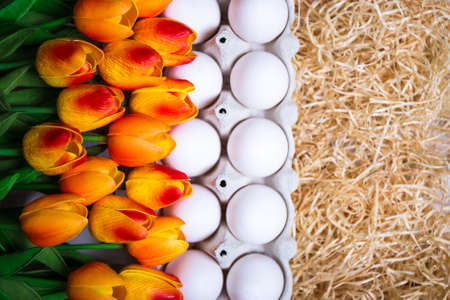 Easter background - close up of box with eggs and tulip flowersの写真素材