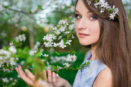 portrait of happy beautiful girl posing in blooming summer gardenの写真素材
