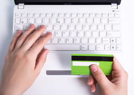 online shopping - female hands with credit card and laptop keyboard