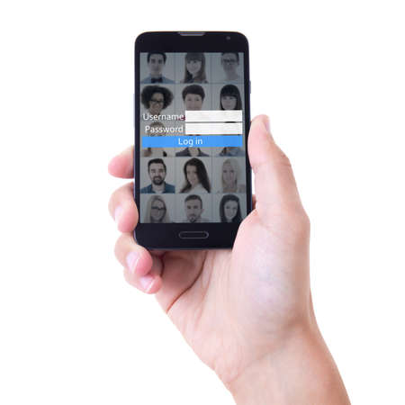 hand holding mobile smart phone with social network login panel on screen isolated on white...
