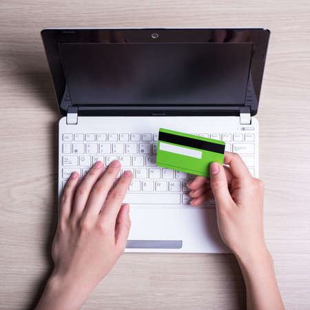 online shopping - laptop and female hands with credit card