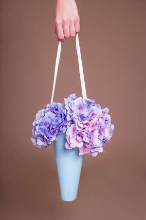 close up of paper box with hydrangea flowers in female handsの写真素材
