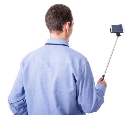 young business man taking selfie photo with smart phone on selfie stick isolated on white background