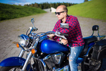 young handsome man sitting on beautiful retro motorcycleの写真素材