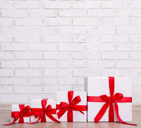 christmas background - gift boxes over white brick wall