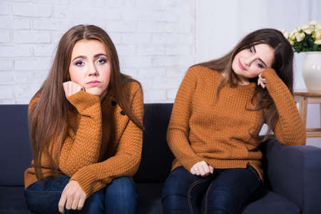 friendship, conflict or boredom concept - two sad girls after quarrel