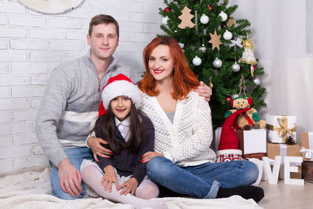 happy family portrait with decorated Christmas treeの写真素材