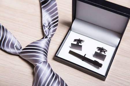close up of tie and cufflinks on wooden tableの写真素材