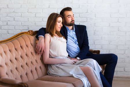 relationship and love concept - young beautiful couple sitting and dreaming about somethingの写真素材