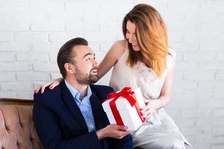 holiday concept -pretty girl giving gift box to her boyfriendの写真素材