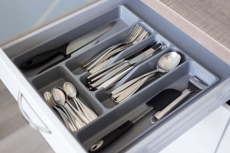 drawer with silver cutlery in modern kitchenの写真素材