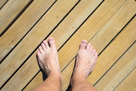 top view of male legs over wooden beach road