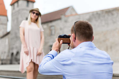 travel concept - happy tourist taking photo of his wife or girlfriendの写真素材
