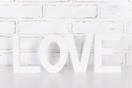 wooden letters LOVE over white brick wallの写真素材
