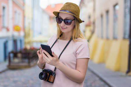 portrait of young woman tourist with camera and smart phoneの写真素材