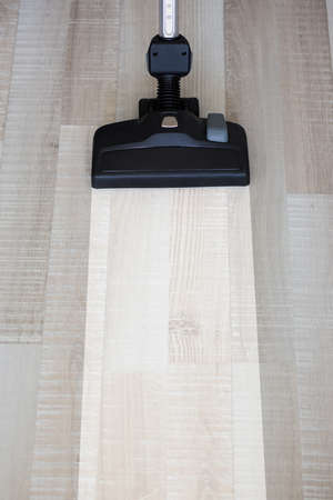 housekeeping before and after concept - vacuum cleaner over wooden floor backgroundの写真素材
