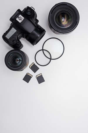 dslr camera, lenses, photo equipment and copy space over white table background
