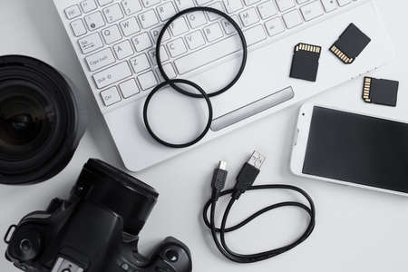 top view of camera, lenses, photography equipment, smart phone and laptop over white backgroundの写真素材