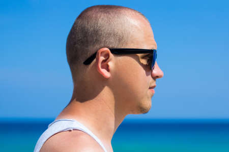 close up portrait of young man over summer beach background