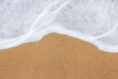summer background - top view of golden sandy beach and sea waterの写真素材