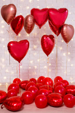 Valentine's day background - group of red balloons over white brick wallの写真素材