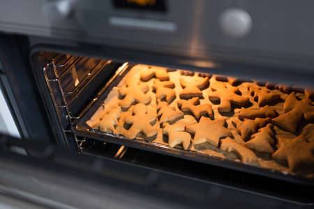 bakery and cooking - close up of cookies or gingerbreads in ovenの写真素材
