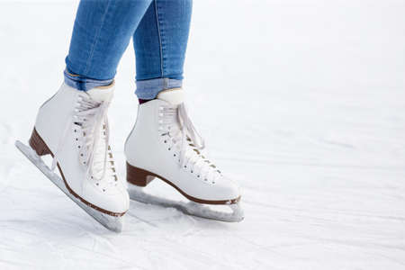 close up of legs in new leather skates and copy space over white ice at rinkの写真素材