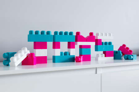 word toys - close up of colorful letters folded of toy constructor over white background