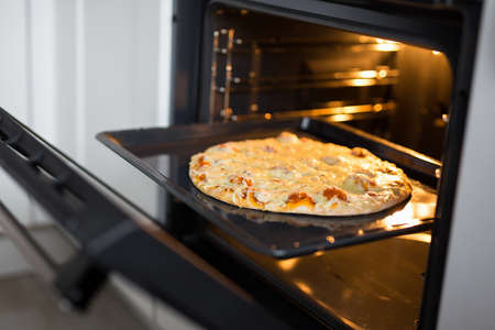 close up of tasty homemade cheese pizza in hot ovenの写真素材