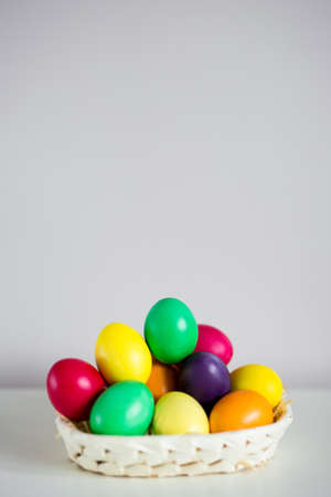 Easter background - colorful eggs on the table with copy space over wallの写真素材