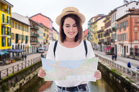 portrait of young beautiful woman tourist walking with map in old italian town