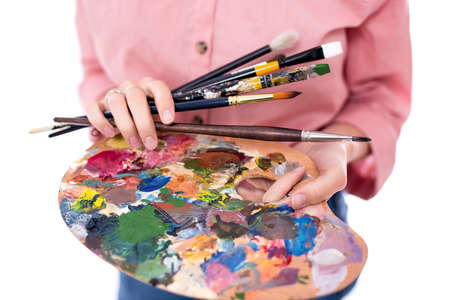 palette and paint brush in female hands isolated on white background